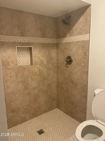 a bathroom with a toilet and a shower