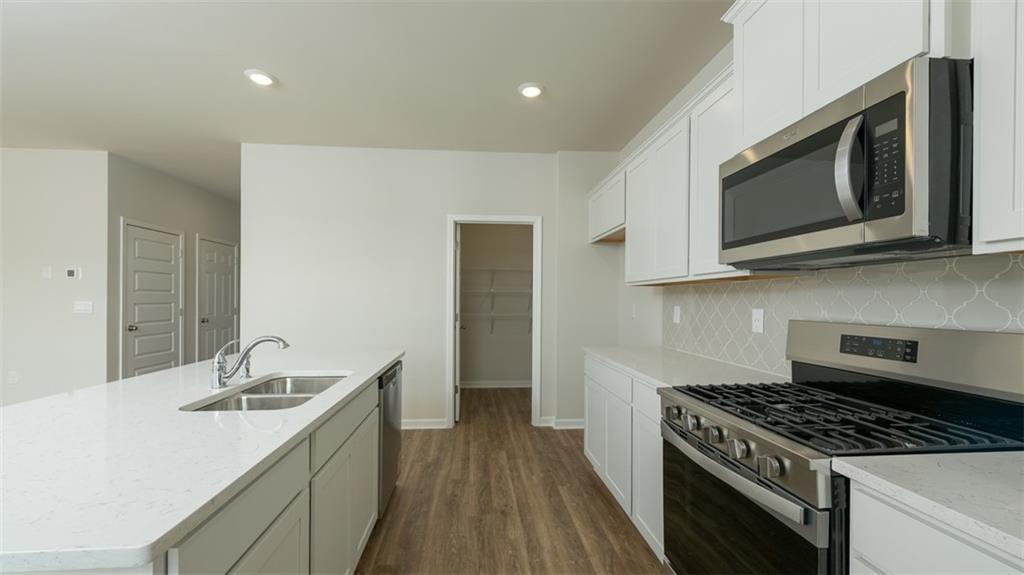 488 Bullock Pass Jefferson, GA 30549 - Photo 11 of 61 a kitchen with stainless steel appliances a stove a microwave a sink and cabinets