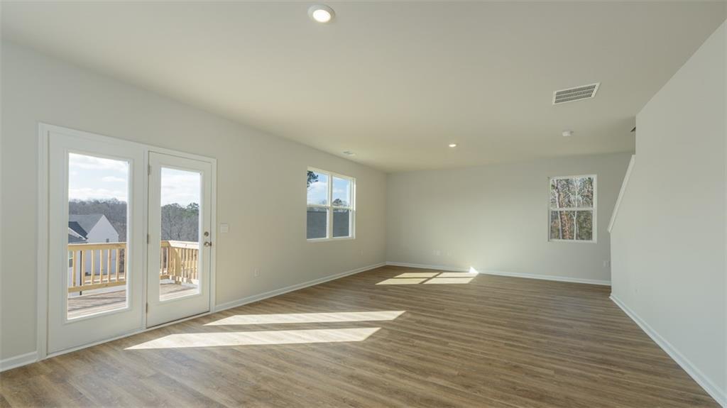 488 Bullock Pass Jefferson, GA 30549 - Photo 13 of 61 a view of an empty room with wooden floor and a window