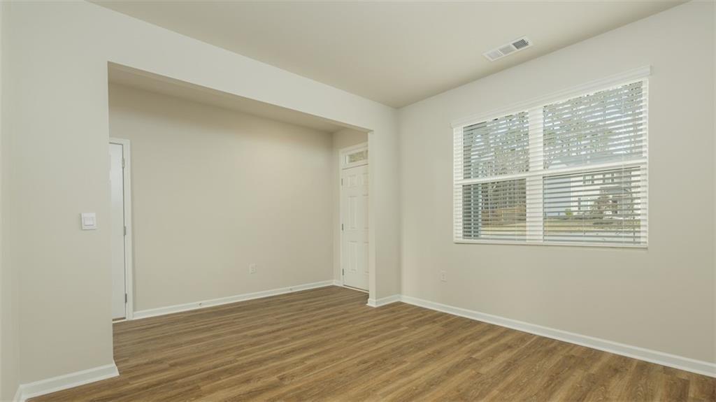 488 Bullock Pass Jefferson, GA 30549 - Photo 5 of 61 a view of an empty room with wooden floor and a window