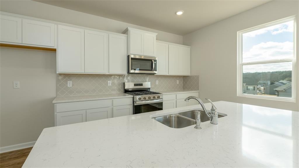 488 Bullock Pass Jefferson, GA 30549 - Photo 10 of 61 a kitchen with granite countertop white cabinets and a stove top oven