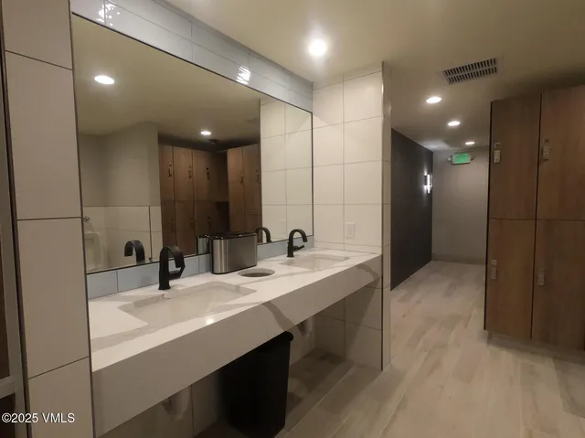 a bathroom with a double vanity sink a mirror and a shower