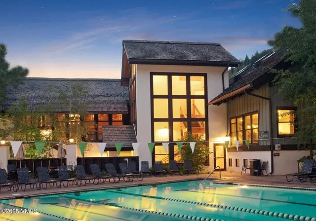 a view of swimming pool with outdoor seating and house in the background