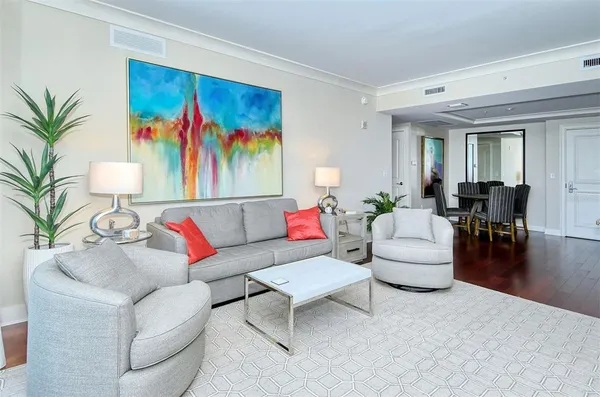 a living room with furniture and painting on the wall with wooden floor