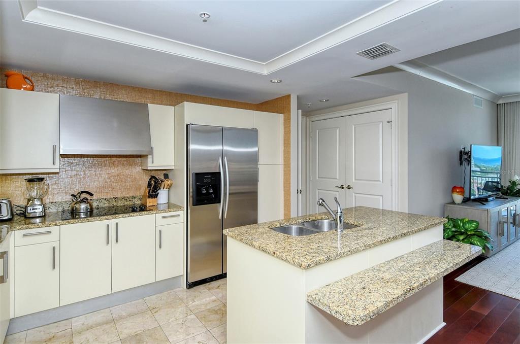1350 Main Street, Unit 1202 Sarasota, FL 34236 - Photo 13 of 41 a kitchen with granite countertop a sink a stove and refrigerator