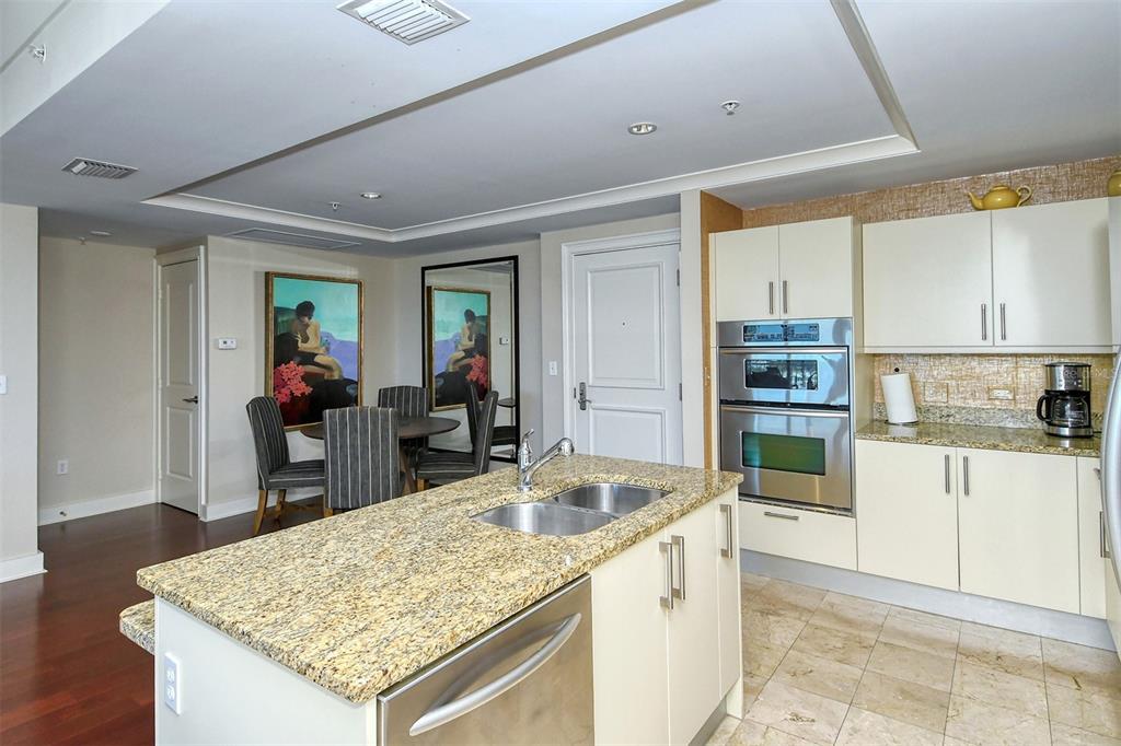 1350 Main Street, Unit 1202 Sarasota, FL 34236 - Photo 15 of 41 a kitchen with stainless steel appliances granite countertop sink refrigerator and cabinets