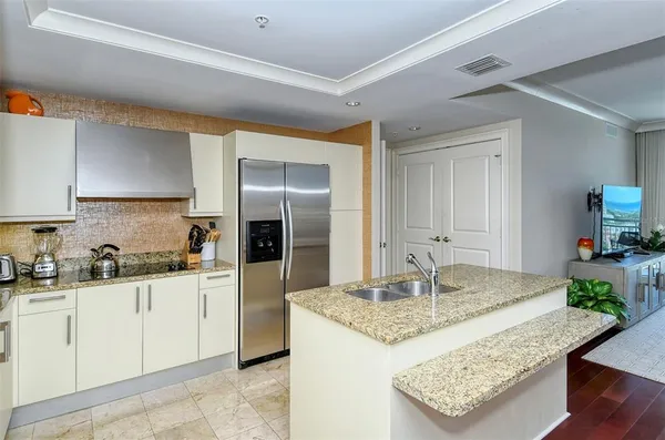 a kitchen with kitchen island granite countertop a sink stove and refrigerator