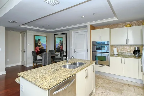 a kitchen with a sink a counter space and wooden floor