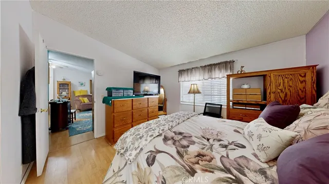 a bedroom with a large bed and a flat tv screen