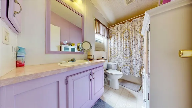 a bathroom with a granite countertop sink mirror vanity and toilet