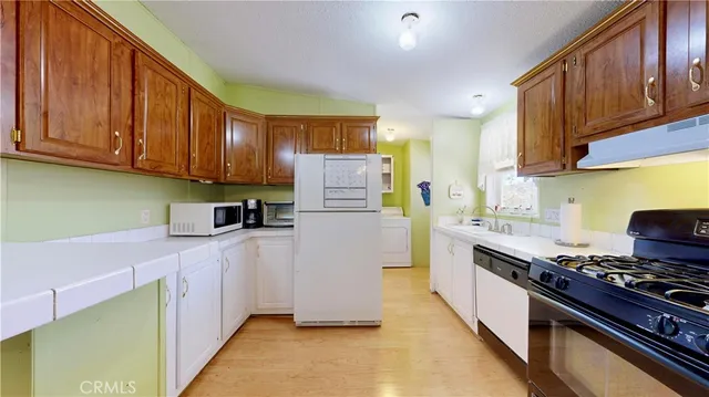 a kitchen with stainless steel appliances granite countertop a refrigerator a stove and a sink