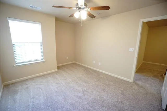 an empty room with a window and a fan