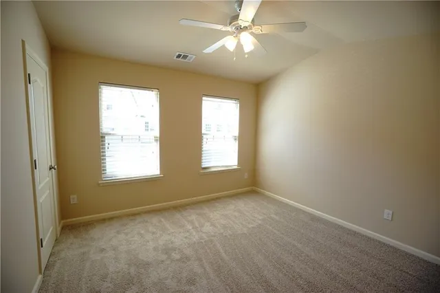 an empty room with closet and a chandelier fan
