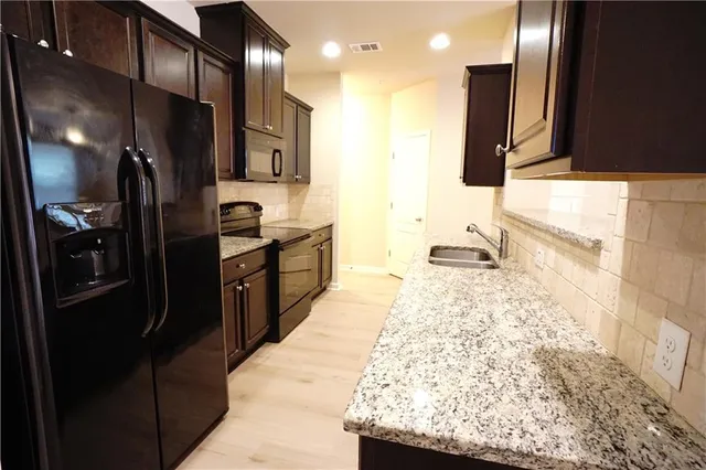 a kitchen with granite countertop stainless steel appliances and wooden cabinets
