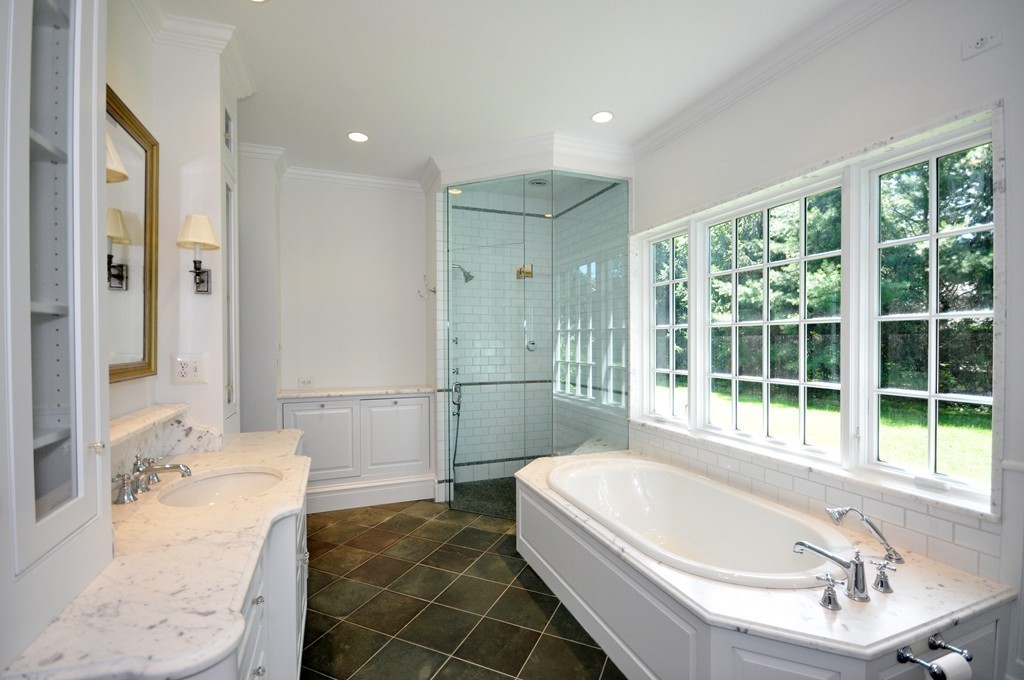 285 Musketaquid Road Concord, MA 01742 - Photo 14 of 30 a bathroom with a large tub a sink a window and a shower
