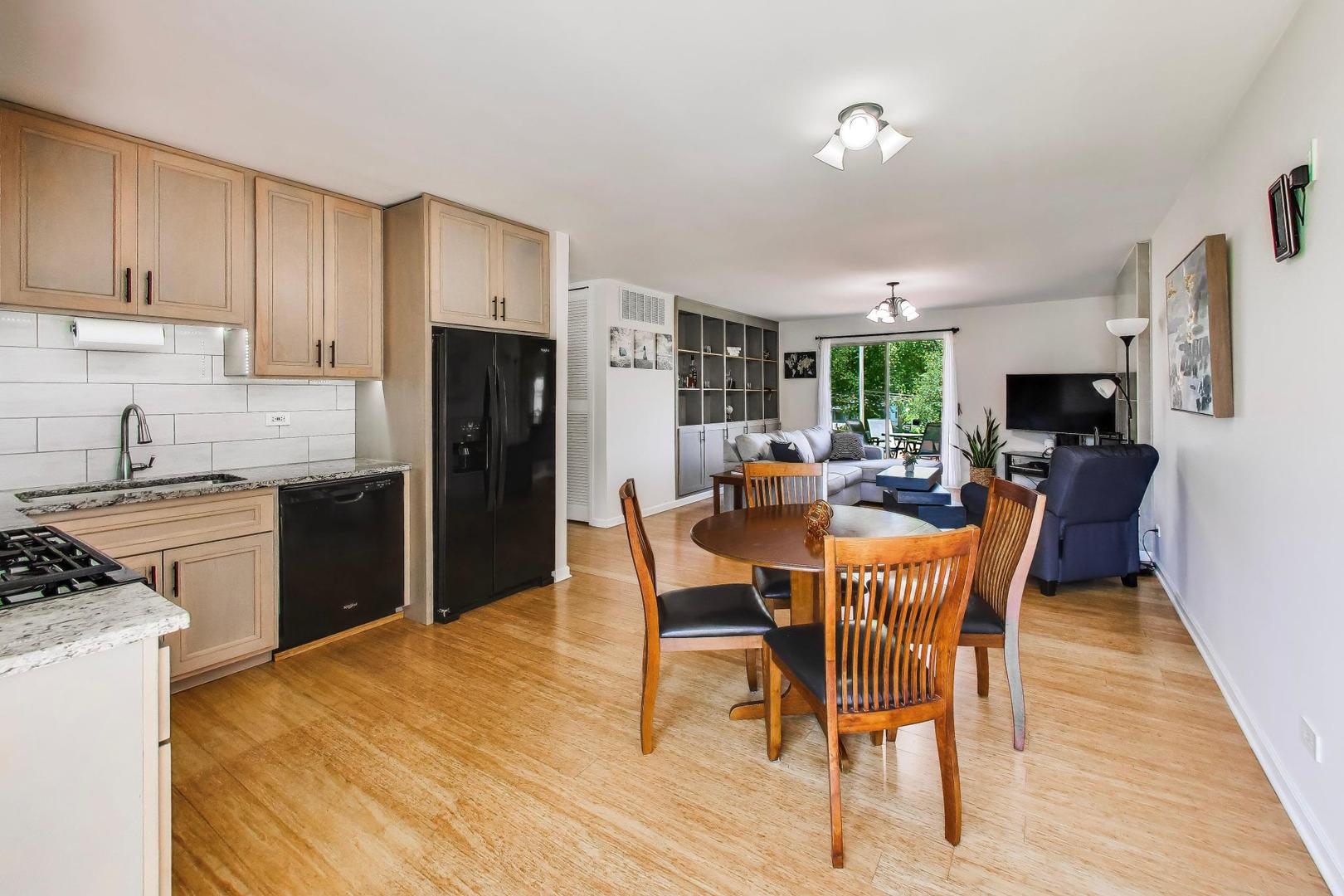 420 Bode Road Hoffman Estates, IL 60169 - Photo 7 of 20 a kitchen with stainless steel appliances granite countertop a refrigerator a stove a sink a dining table and chairs with wooden floor