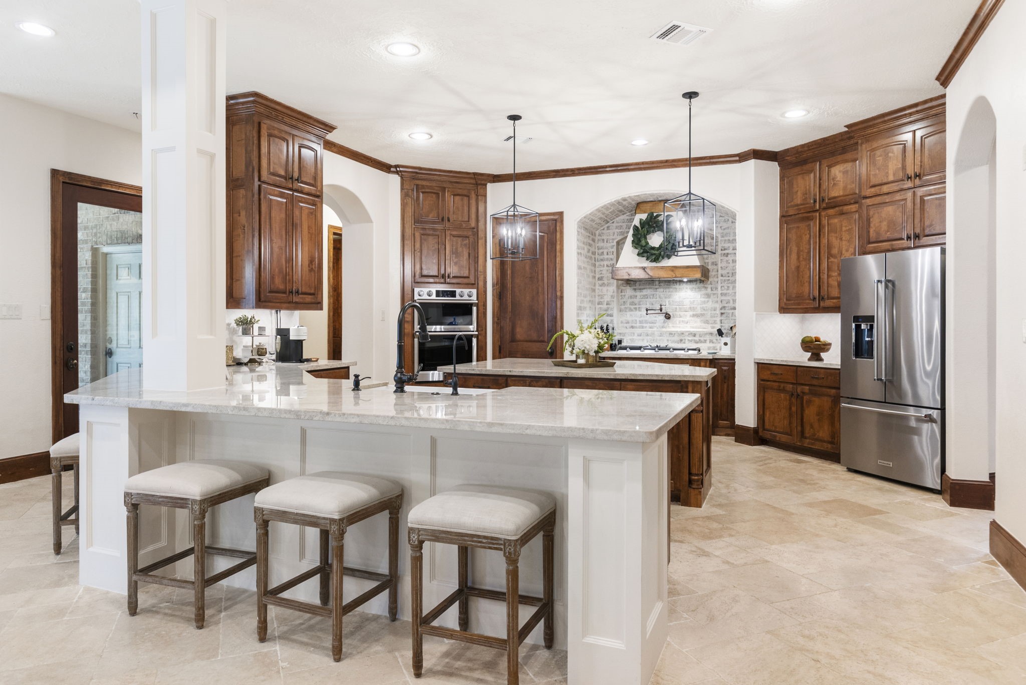 7421 Enchanted Stream Drive Conroe, TX 77304 - Photo 12 of 50 a kitchen with stainless steel appliances kitchen island granite countertop a table chairs stove and refrigerator