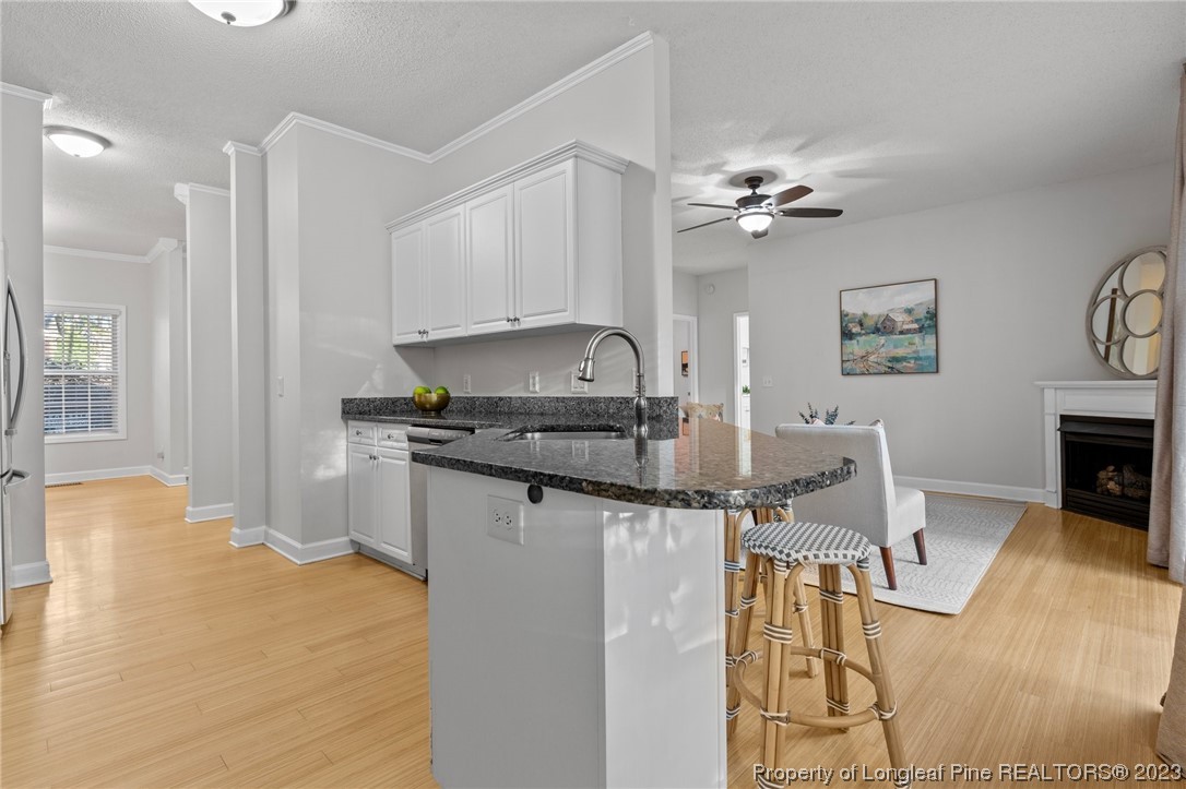 45 Sawmill Road West Pinehurst, NC 28374 - Photo 13 of 36 a kitchen with granite countertop a stove a sink and a refrigerator with wooden floor
