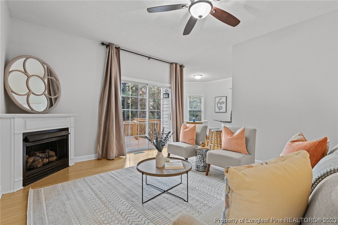45 Sawmill Road West Pinehurst, NC 28374 - Photo 6 of 36 a living room with furniture a fireplace and a floor to ceiling window