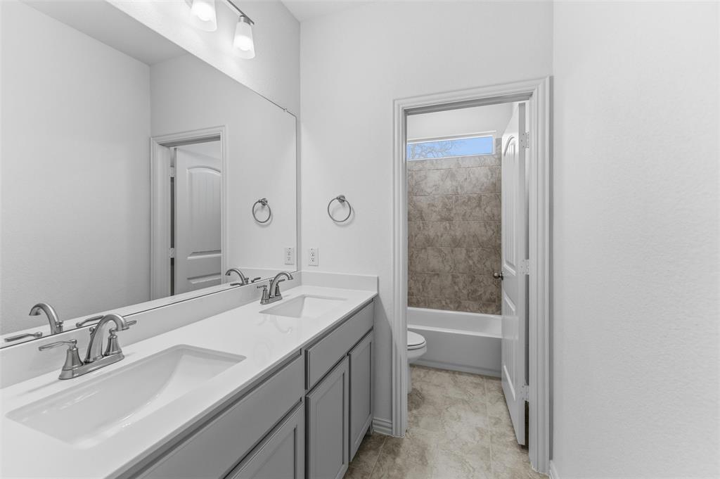 144 Oak Grv Way Springtown, TX 76082 - Photo 20 of 27 a bathroom with a granite countertop sink a toilet and shower