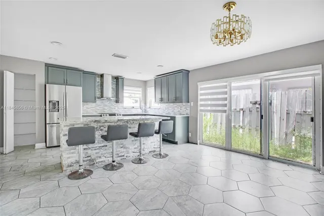 a kitchen with stainless steel appliances kitchen island granite countertop a refrigerator and a stove