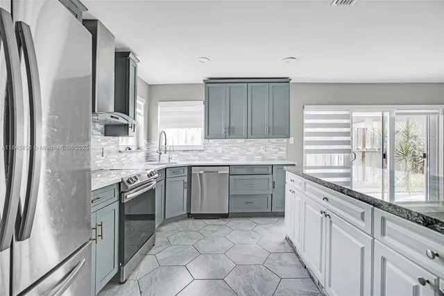 a kitchen with stainless steel appliances granite countertop a sink stove and refrigerator