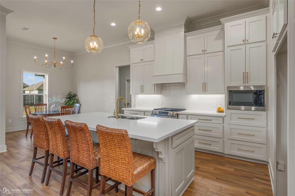 219 Marble Place Haughton, LA 71037 - Photo 12 of 29 Kitchen featuring white shaker cabinetry, stainless steel appliances, quartz countertops, wood-finish flooring, and recessed lighting