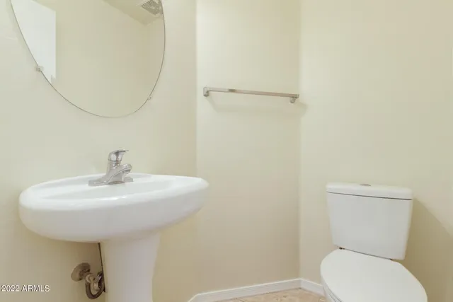 an empty room with chandelier fan and windows