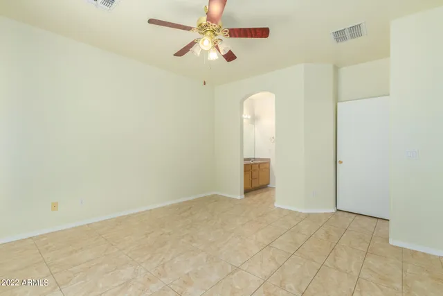 an empty room with fan and windows