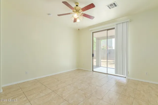 an empty room with a chandelier fan and closet