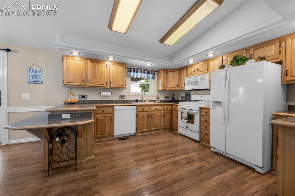 28230 Washington Road Calhan, CO 80808 - Photo 12 of 40 a kitchen with a white cabinets a sink a window a wooden floor and stainless steel appliances