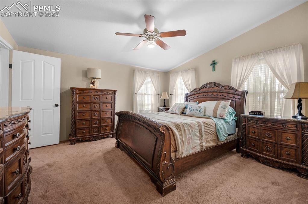 28230 Washington Road Calhan, CO 80808 - Photo 15 of 40 a spacious bedroom with a bed a dresser and a chandelier