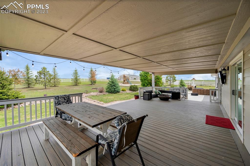 28230 Washington Road Calhan, CO 80808 - Photo 4 of 40 a view of a patio with dining table and chairs with wooden floor