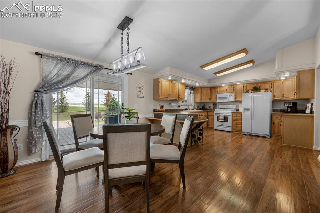 28230 Washington Road Calhan, CO 80808 - Photo 10 of 40 a dining room with wooden floor a chandelier a wooden table and chairs