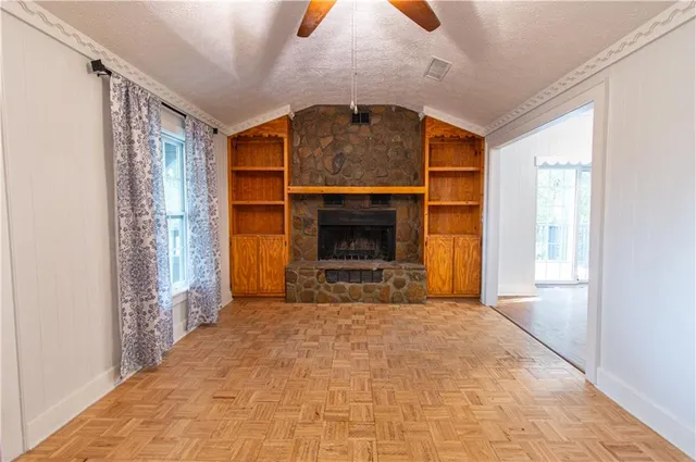 a view of empty room with a fireplace and window