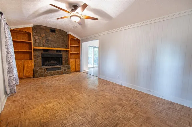 a view of a livingroom with a fireplace and a ceiling fan