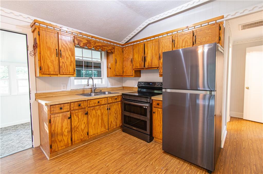 250 Nottingham Way Fairmount, GA 30139 - Photo 14 of 43 a kitchen with stainless steel appliances granite countertop a refrigerator a sink and a stove