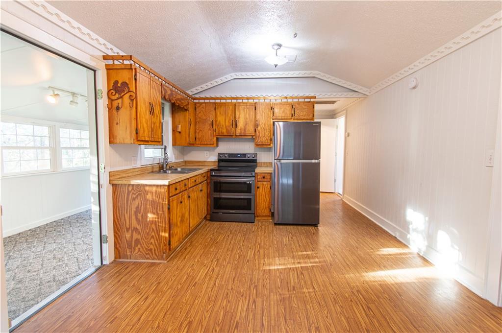 250 Nottingham Way Fairmount, GA 30139 - Photo 16 of 43 a kitchen with stainless steel appliances a stove a refrigerator and cabinets