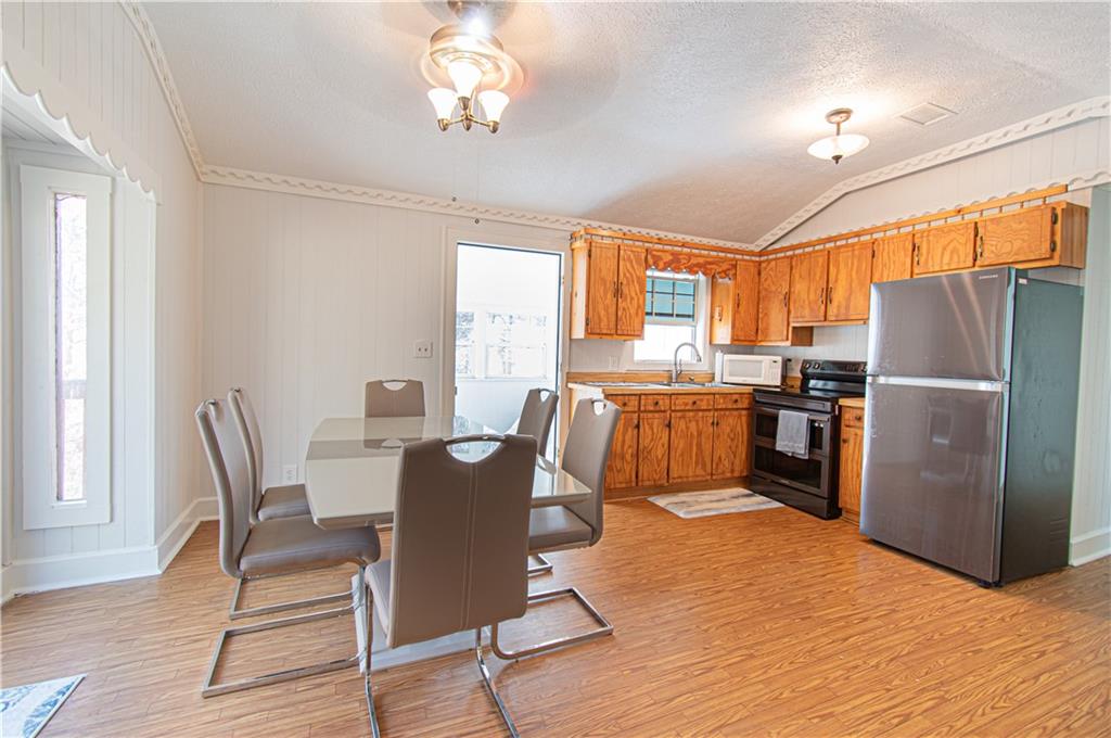 250 Nottingham Way Fairmount, GA 30139 - Photo 17 of 43 a kitchen with granite countertop a refrigerator a stove a dining table and chairs
