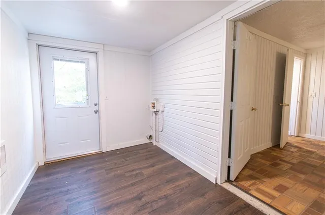 an empty room with wooden floor and white walls