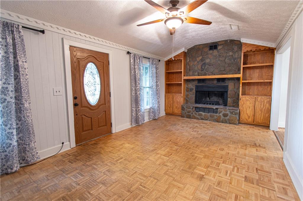 250 Nottingham Way Fairmount, GA 30139 - Photo 10 of 43 a view of a livingroom with a fireplace a ceiling fan and wooden floor