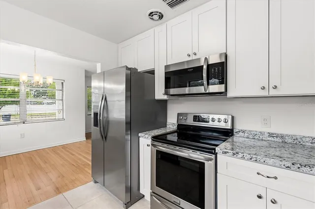 a kitchen with stainless steel appliances granite countertop a stove a microwave and a refrigerator