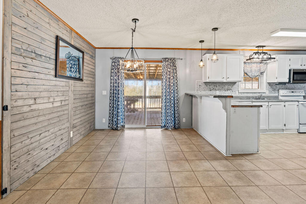 18097 Country Cross Road Florala, AL 36442 - Photo 14 of 32 a kitchen with stainless steel appliances granite countertop a stove a sink and white cabinets