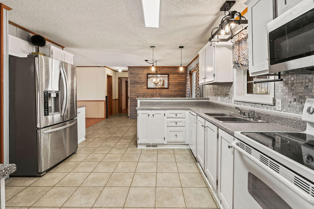 18097 Country Cross Road Florala, AL 36442 - Photo 22 of 32 a kitchen with stainless steel appliances granite countertop a refrigerator and a stove top oven
