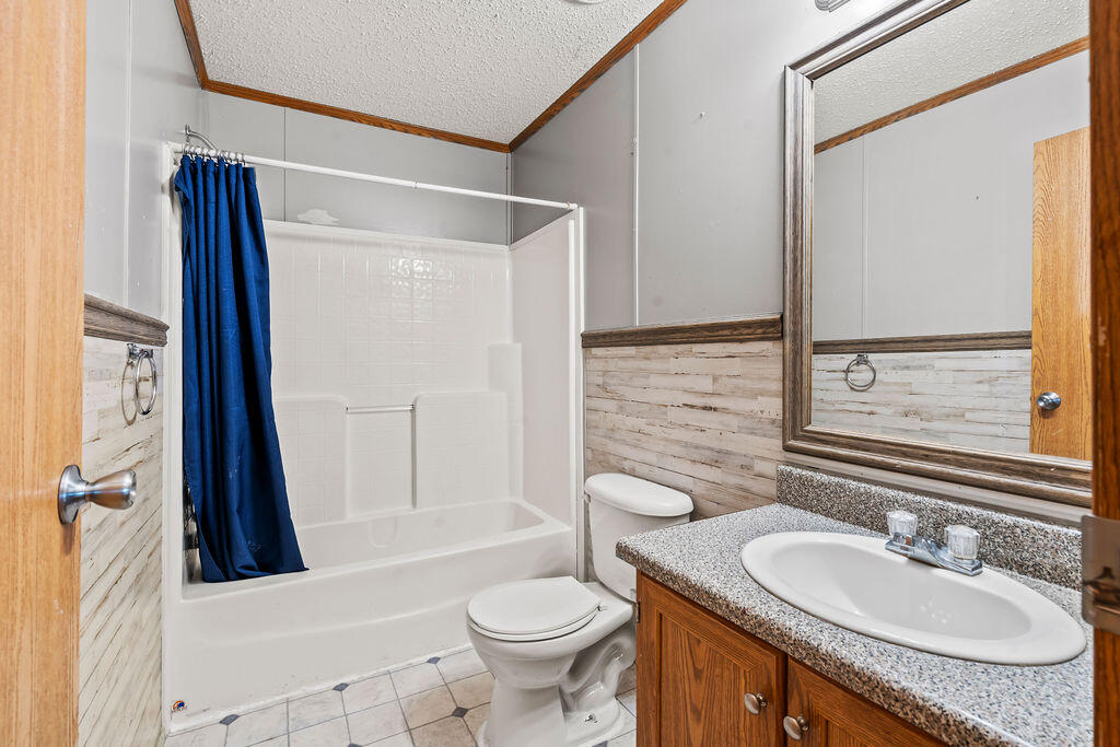 18097 Country Cross Road Florala, AL 36442 - Photo 3 of 32 a bathroom with a granite countertop sink toilet and shower