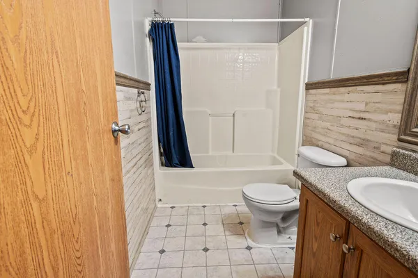 a bathroom with a granite countertop sink toilet and shower