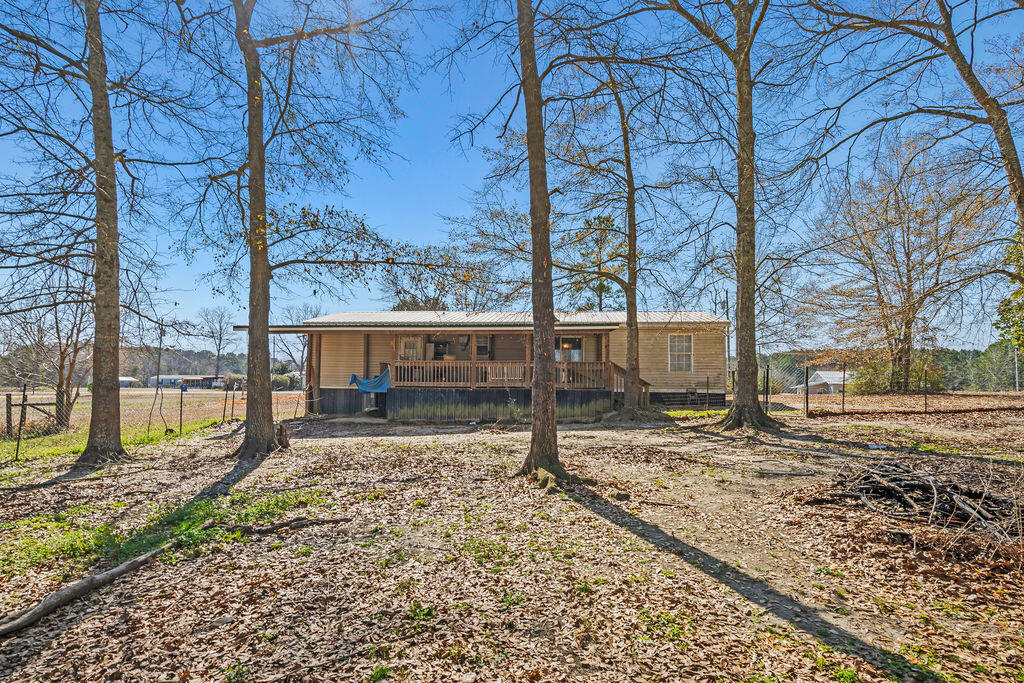 18097 Country Cross Road Florala, AL 36442 - Photo 5 of 32 a view of a yard with wooden fence and a bench