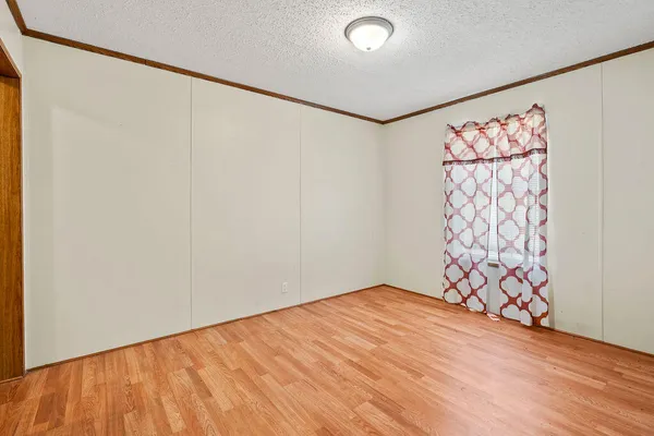 a view of an empty room with a window and a shower curtain