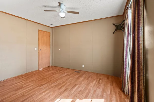 a view of empty room with wooden floor