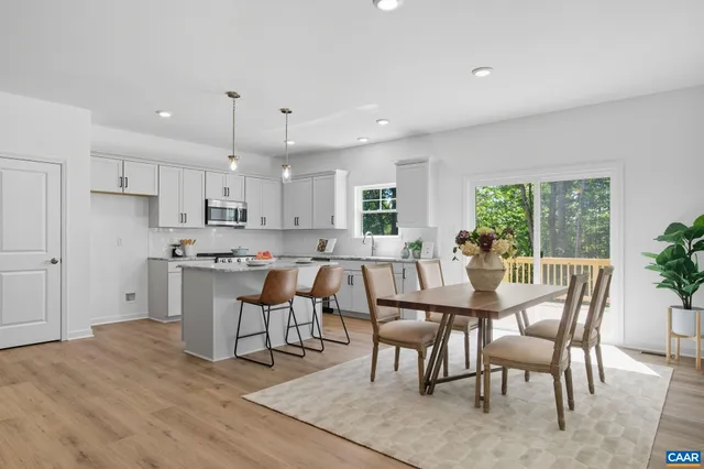 a view of a dining room and livingroom with furniture wooden floor a chandelier